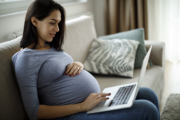 pregnant woman with laptop during an online genetic counseling appointment